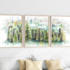 three woodland pine forest watercolor paintings framed over a white sofa